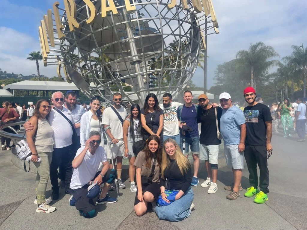 people posing in front of a globe structure